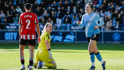 A soccer match scene with a player in a light blue jersey and number 11 celebrating a goal, while opponents include a player in red and white stripes and a goalkeeper in yellow.