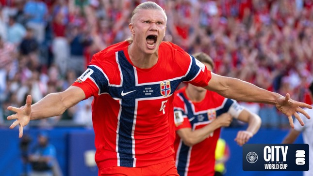 A football player in a red Norway jersey celebrating in a stadium. The jersey has the Norway flag design and the Manchester City logo appears in the corner.