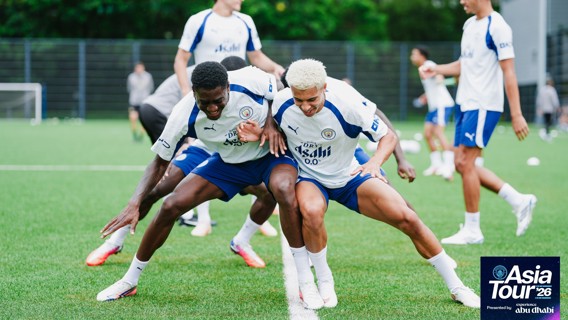 Manchester City players in training session during Asia Tour '26. They are wearing Puma training kits, and the image includes a logo in the bottom corner.