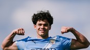 A football player in a Manchester City jersey flexes their muscles in a victory pose. The Manchester City logo is visible.