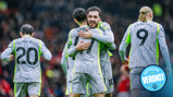 Manchester City players in gray and neon kits are seen hugging on the field. The players have visible names on their jerseys: Bernardo, Haaland, and Foden.
