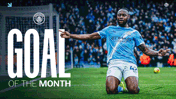 A Manchester City player celebrates a goal on the field. The text reads 'Goal of the Month' with the Manchester City logo visible.