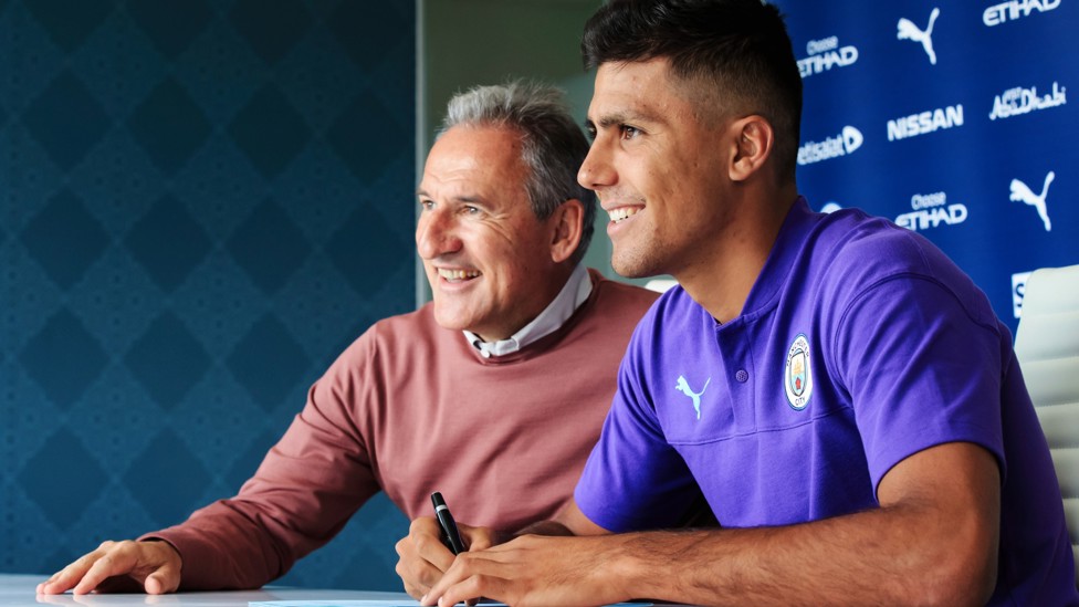 SIGNED UP : Rodri puts pen to paper on his City contract in July 2019.