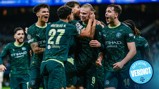 Manchester City players in green jerseys celebrating a goal during a match. The jersey displays the Etihad Airways logo, with number 27 on one player. Faces are blurred.