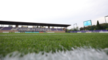 Wide angle view of Fiorentina's stadium with grass in the foreground and scoreboard showing 0-0.