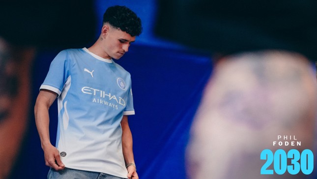 A person wearing a Manchester City jersey featuring Puma and Etihad Airways logos with 'PHIL FODEN 2030' text on the bottom right.