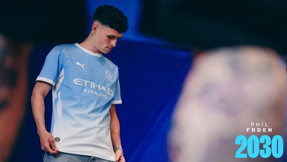 A person wearing a Manchester City jersey featuring Puma and Etihad Airways logos with 'PHIL FODEN 2030' text on the bottom right.