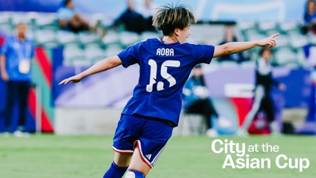 Soccer player with number 15 jersey named Aoba celebrates a goal at the Asian Cup. Background features other players and spectators.