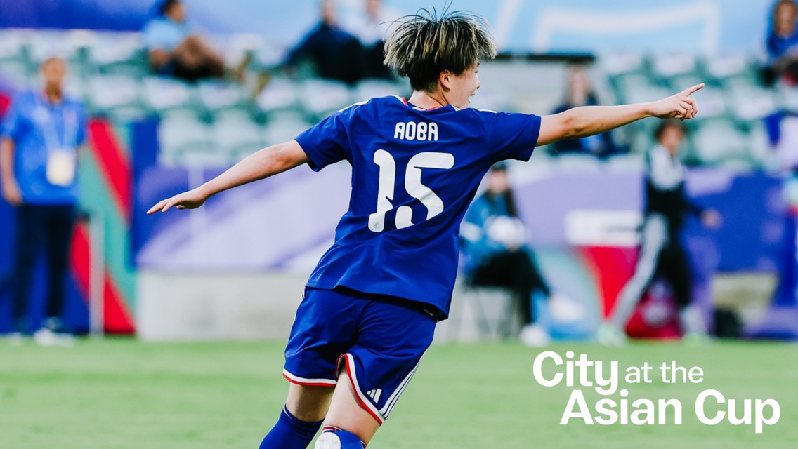 Soccer player with number 15 jersey named Aoba celebrates a goal at the Asian Cup. Background features other players and spectators.