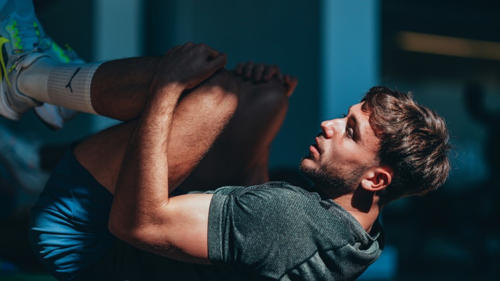 RECOVER  : Nico stretches in the gym.