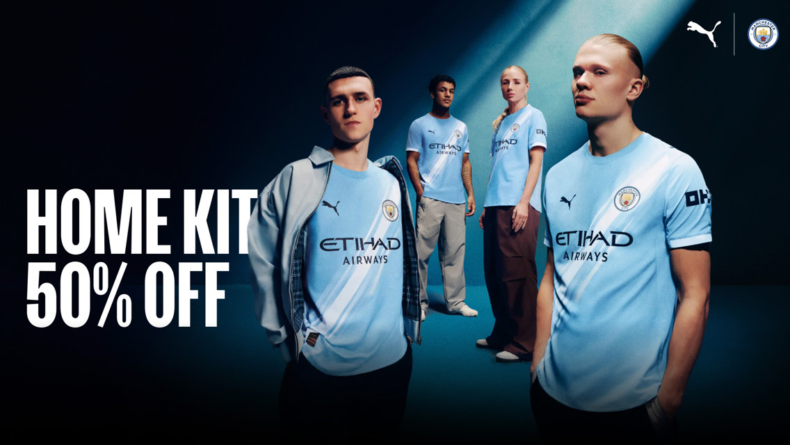 Advertisement for Manchester City home kit showing models wearing the kit. Large text reads 'HOME KIT 50% OFF'. Puma and Manchester City logos are visible.