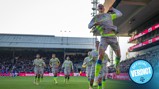 A Manchester City player jumps in celebration after scoring a goal, while teammates follow behind wearing gray and neon kits. 'Official Verdict' text is visible in the corner.