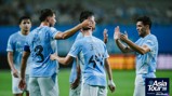 Manchester City players celebrating a goal during the Asia Tour 2026, presented by Abu Dhabi. Players wear light blue kits with Japanese characters. The event logo is visible.