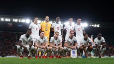 England football team group photo on the field wearing white kits before a match.
