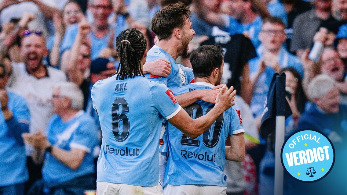 Players in Manchester City kit celebrating a goal, with one labeled Aké. Fans visible in the background. An 'Official Verdict' badge is present.