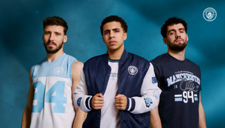 Three individuals modeling Manchester City-themed apparel, including a jersey, jacket, and t-shirt, against a blue background with the Manchester City logo.