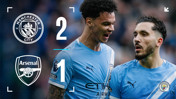 Graphic showing Manchester City 2-1 victory over Arsenal. Manchester City crest and Arsenal crest included. Two unidentified players in Manchester City kit partially visible.