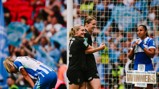 Two players in black jerseys celebrate while one in blue and white kneels. Sign in lower right reads 'Adobe Women's FA Cup Winners 2026'.