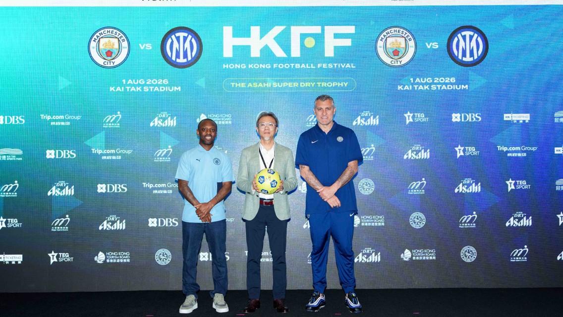 Football press conference announcing the Hong Kong Football Festival with Manchester City vs Inter Milan at Kai Tak Stadium. Three individuals, one holding a ball, stand in front of a backdrop featuring logos and details of the event.