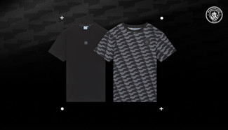 Two Manchester City branded t-shirts: one solid black and one with a gray houndstooth pattern, both featuring the club's crest.