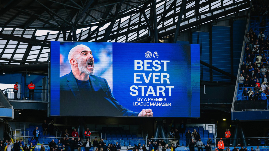 A stadium screen displaying 'Best Ever Start by a Premier League Manager' with an image of a person celebrating.