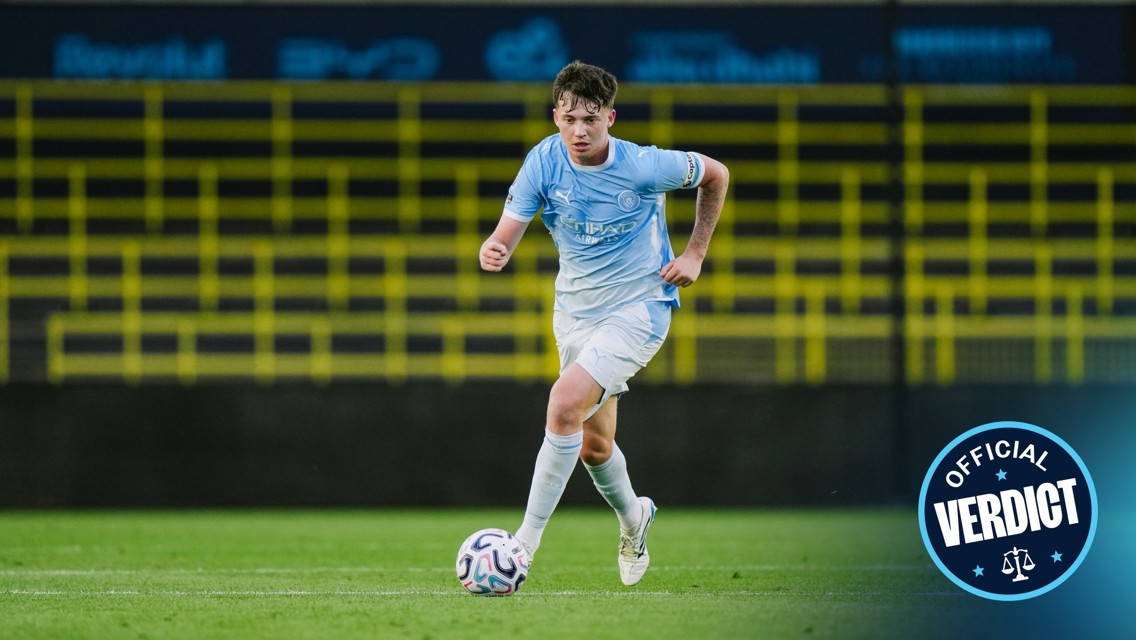 A young soccer player from Manchester City in a light blue kit dribbles the ball on the field with a badge reading 'Official Verdict' in the lower right corner.