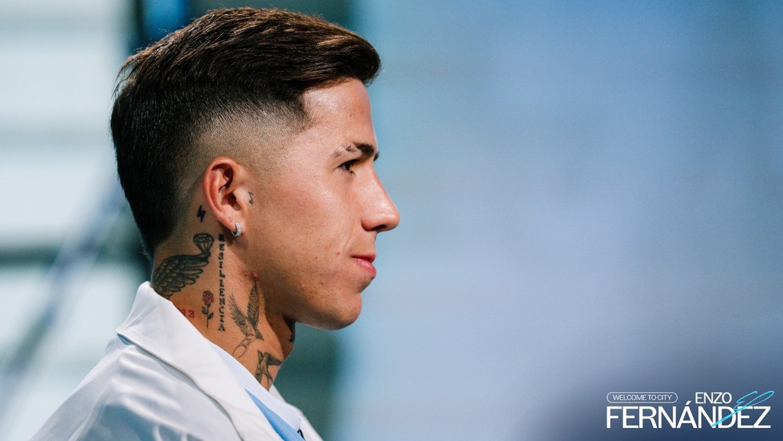 Side profile of a person with tattoos visible on the neck wearing a white shirt. The text 'Enzo Fernández' and 'Welcome to City' are also visible.