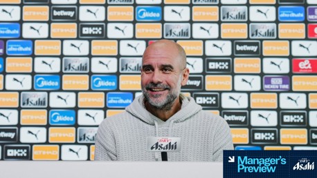 Person at a press conference with logos of Manchester City sponsors in the background. 'Manager's Preview' text in the corner.