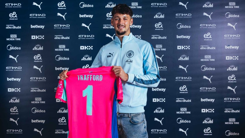GUESS WHO'S BACK: James Trafford proudly holds his shirt after returning to Manchester