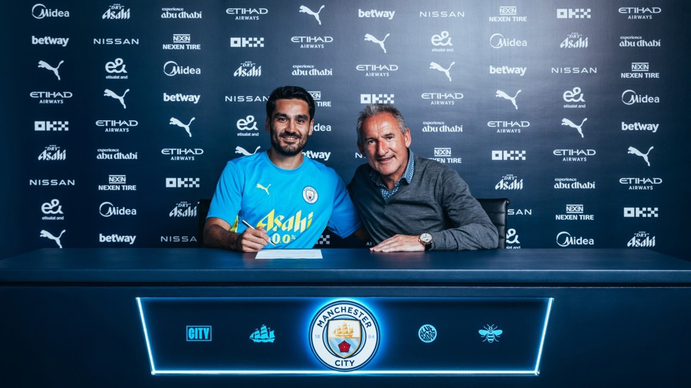 WELCOME BACK :  Ilkay Gundogan signs on the dotted line for City once again as he begins his second spell in the sky blue shirt.