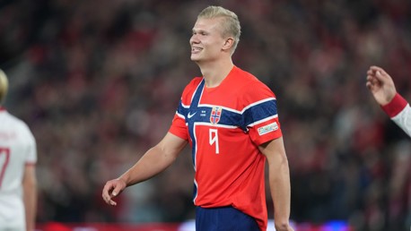 A soccer player wearing an orange Norway national team jersey with the number 9.