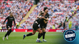 Women's football team celebrates a goal on a stadium with a crowd. Players wearing black jerseys and cheering enthusiastically.