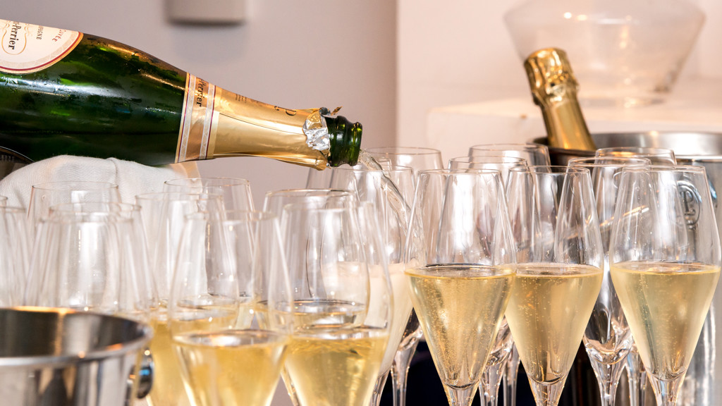Champagne being poured into multiple glasses, likely for a celebration or party setting.