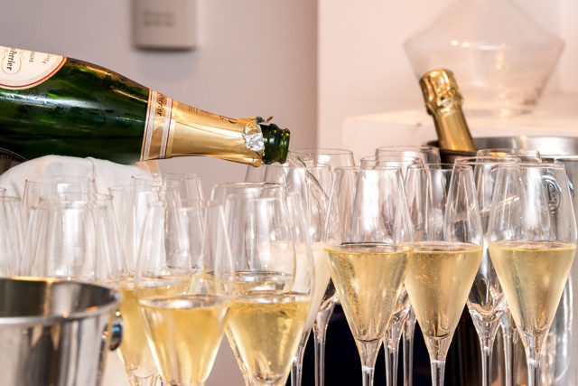 Champagne being poured into multiple glasses, likely for a celebration or party setting.