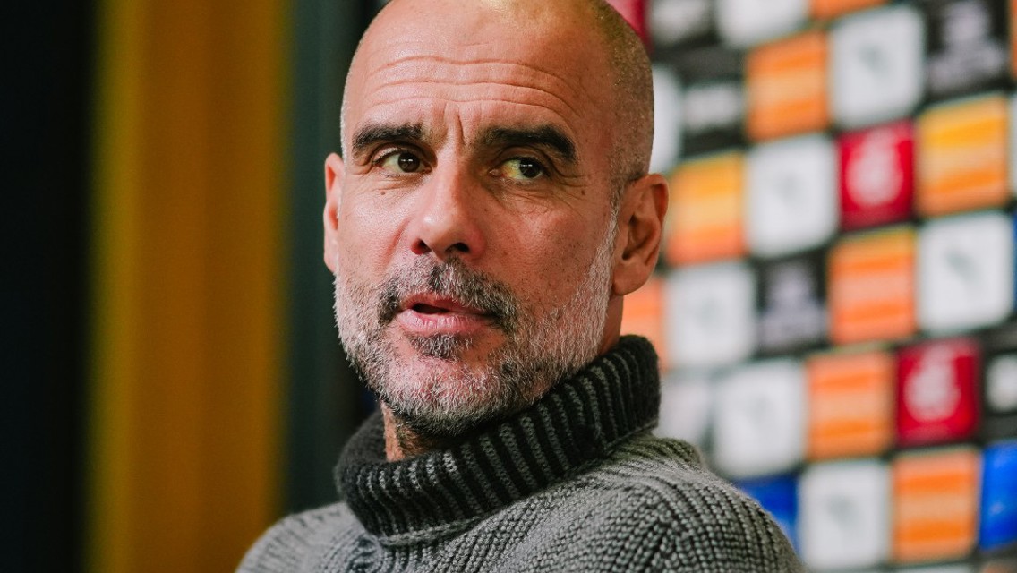 An individual in a grey sweater is seated in front of a backdrop with logos and advertisements during a press conference. Text overlay reads 'Manager's Preview' with 'Asahi Super Dry' branding.