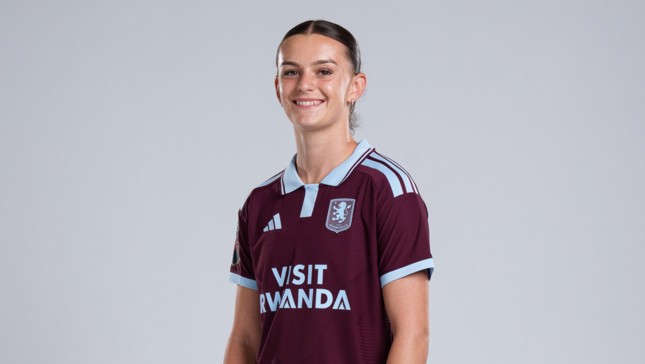 A person wearing an Aston Villa FC jersey in maroon with light blue accents, featuring the 'Visit Rwanda' sponsor and the club crest.