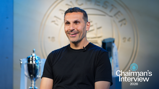 A person in a black shirt with a blurred face sits for an interview in front of a Manchester City logo and trophy display. The text 'Chairman's Interview 2026' is shown.