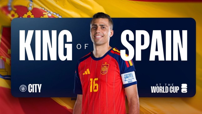 A soccer player in a Spanish jersey is standing in front of a banner reading 'King of Spain' with 'World Cup' and 'City' logos.