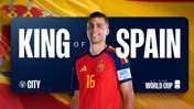 A soccer player in a Spanish jersey is standing in front of a banner reading 'King of Spain' with 'World Cup' and 'City' logos.