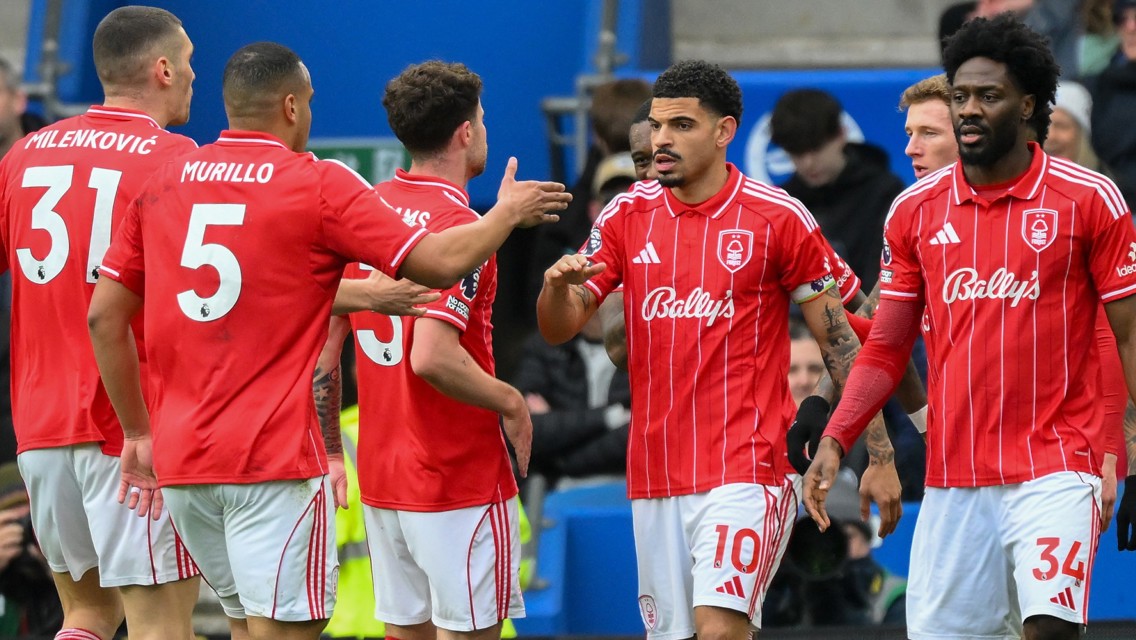 Nottingham Forest players celebrating in red and white striped jerseys with sponsor 'Bally's'.