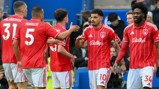 Nottingham Forest players celebrating in red and white striped jerseys with sponsor 'Bally's'.