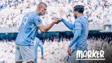 Two Manchester City players in blue jerseys are on the field performing a fist bump. The text 'Monday Marker' is visible in the bottom right corner.