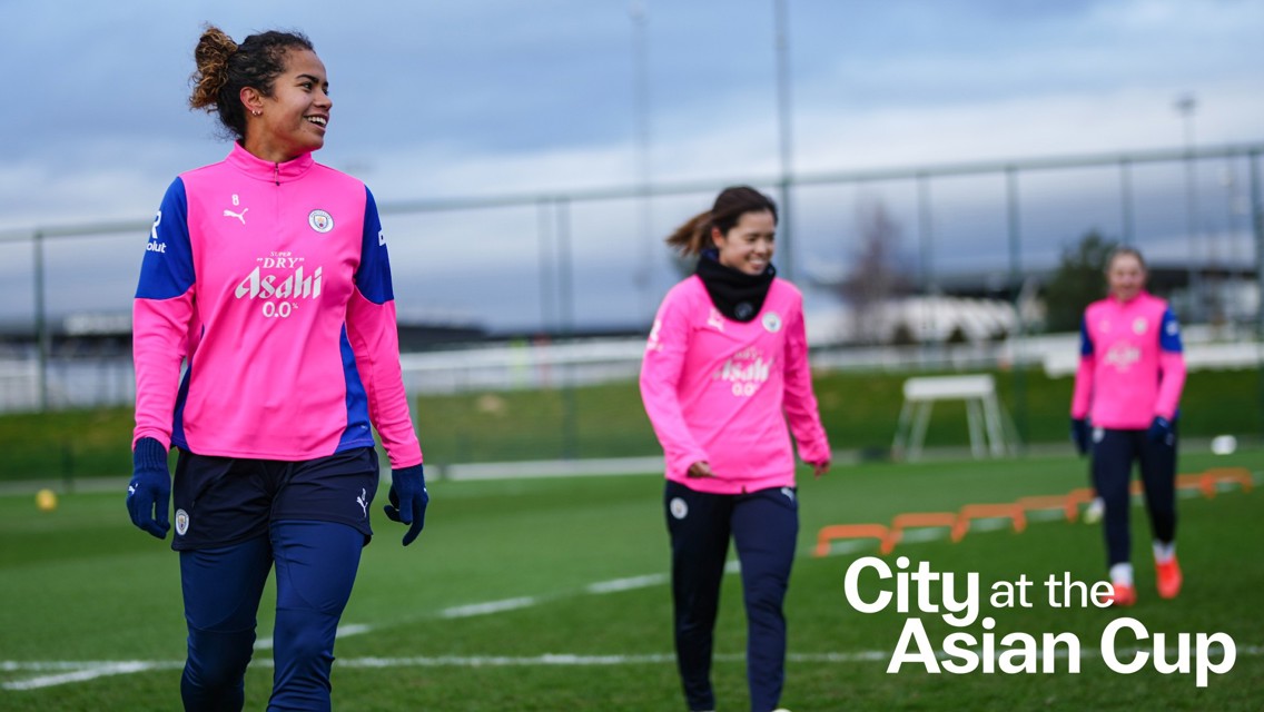 Three players from Manchester City Women's team in pink training kits on a field with the text 'City at the Asian Cup'.