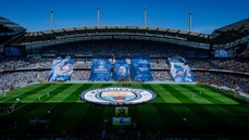 A wide view of Manchester City's Etihad Stadium with large banners celebrating '10 Years with Pep'. The stadium is filled with fans and features the Manchester City logo on the pitch.