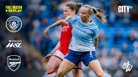 Two female footballers, one in a Manchester City kit and the other in an Arsenal kit, competing for the ball during a match with Manchester City and Barclays WSL logos visible.