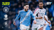 Manchester City player in a blue kit competes for the ball with a Salford City player in a white kit during an FA Cup match, as part of a full match replay on CITY+.