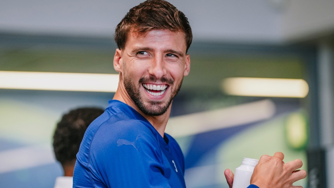 A person wearing a blue Puma shirt is smiling while holding a container.