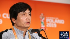 Individual speaking at a press conference for the 2019 FIFA U-20 World Cup. Background features event branding for the Asia Tour '26.