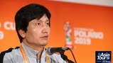 Individual speaking at a press conference for the 2019 FIFA U-20 World Cup. Background features event branding for the Asia Tour '26.