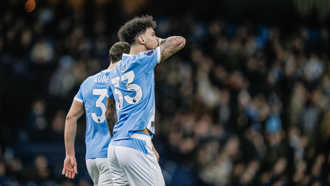 Two soccer players from Manchester City, one wearing jersey number 3 and the other with number 33, are on the field during a match.